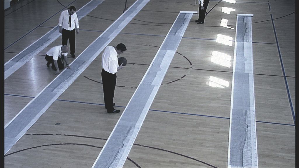 Picture of paper rolls with seismic data rolled out on the floor.